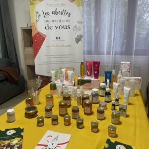 Table avec divers produits de Secret de Miel et une pancarte de présentation