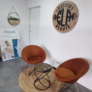 salle d'attente de l'institut ELA beauté avec 2 petits fauteuil marron avec une petite table basse