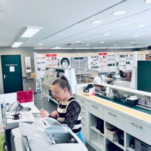 photo de l'intérieur de la boutique Générale optique à Bollène avec une opticienne qui prépare des lunettes